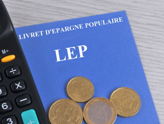 Livret d'épargne populaire associé à une calculatriceet des pièces de monnaie