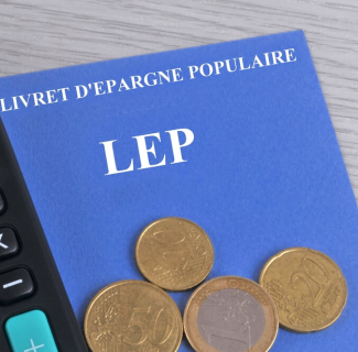 Livret d'épargne populaire associé à une calculatriceet des pièces de monnaie