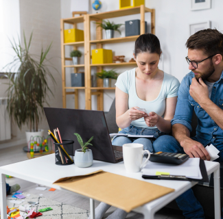 couple faisant ses comptes devant un ordinateur portable