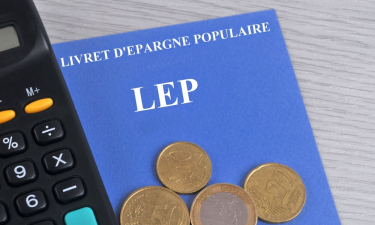 Livret d'épargne populaire associé à une calculatriceet des pièces de monnaie